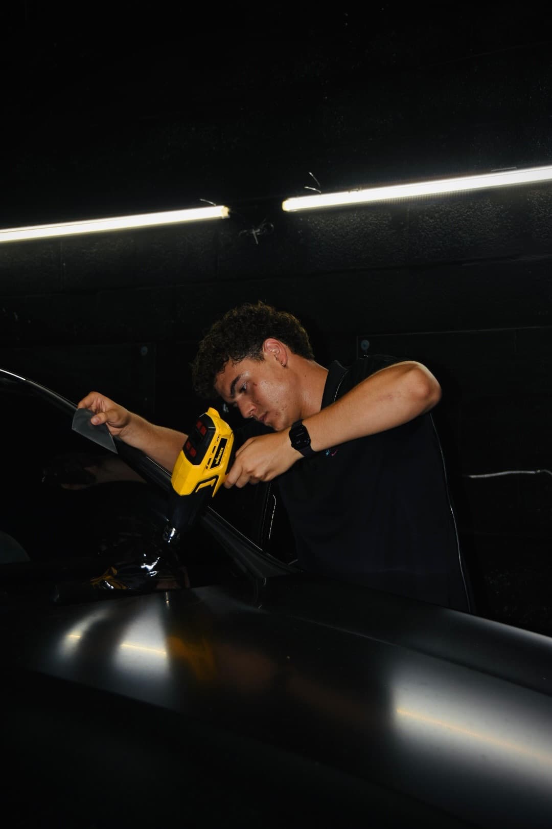 Dr. Tints Miami technician heat-forming ceramic film on car window